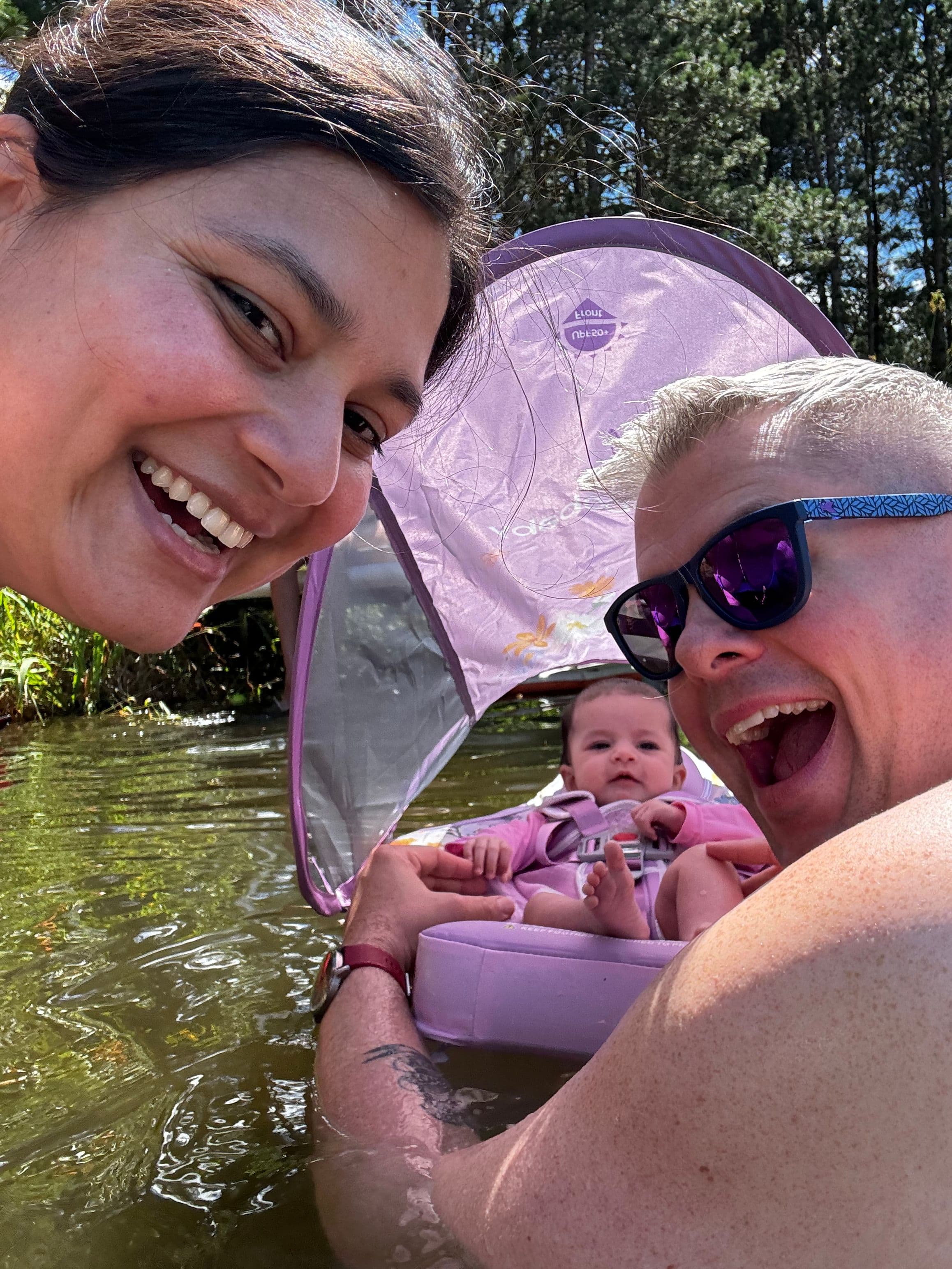 a selfie with two adults and a baby in a water float