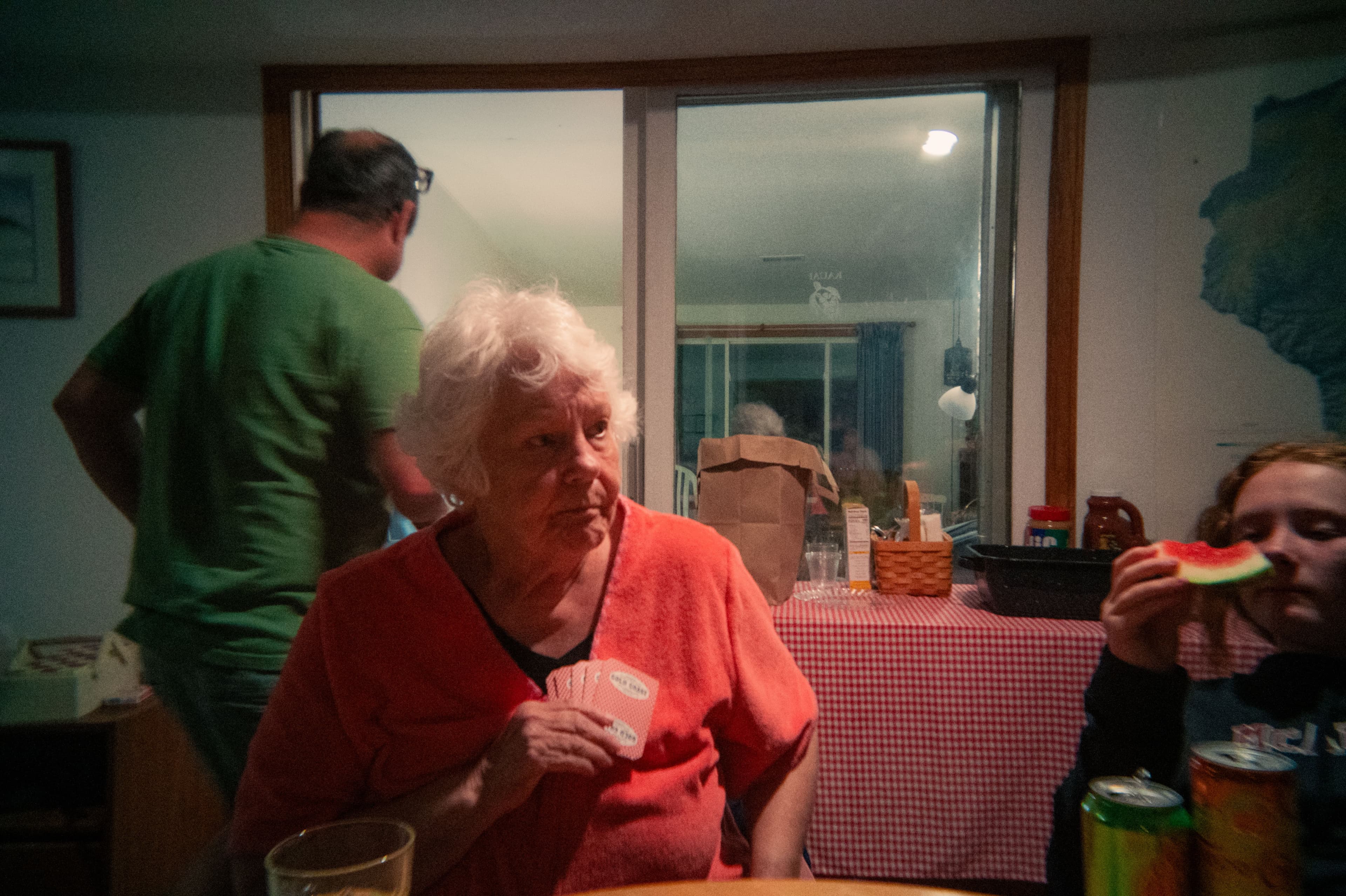 A woman holding a hand of cards close to her chest