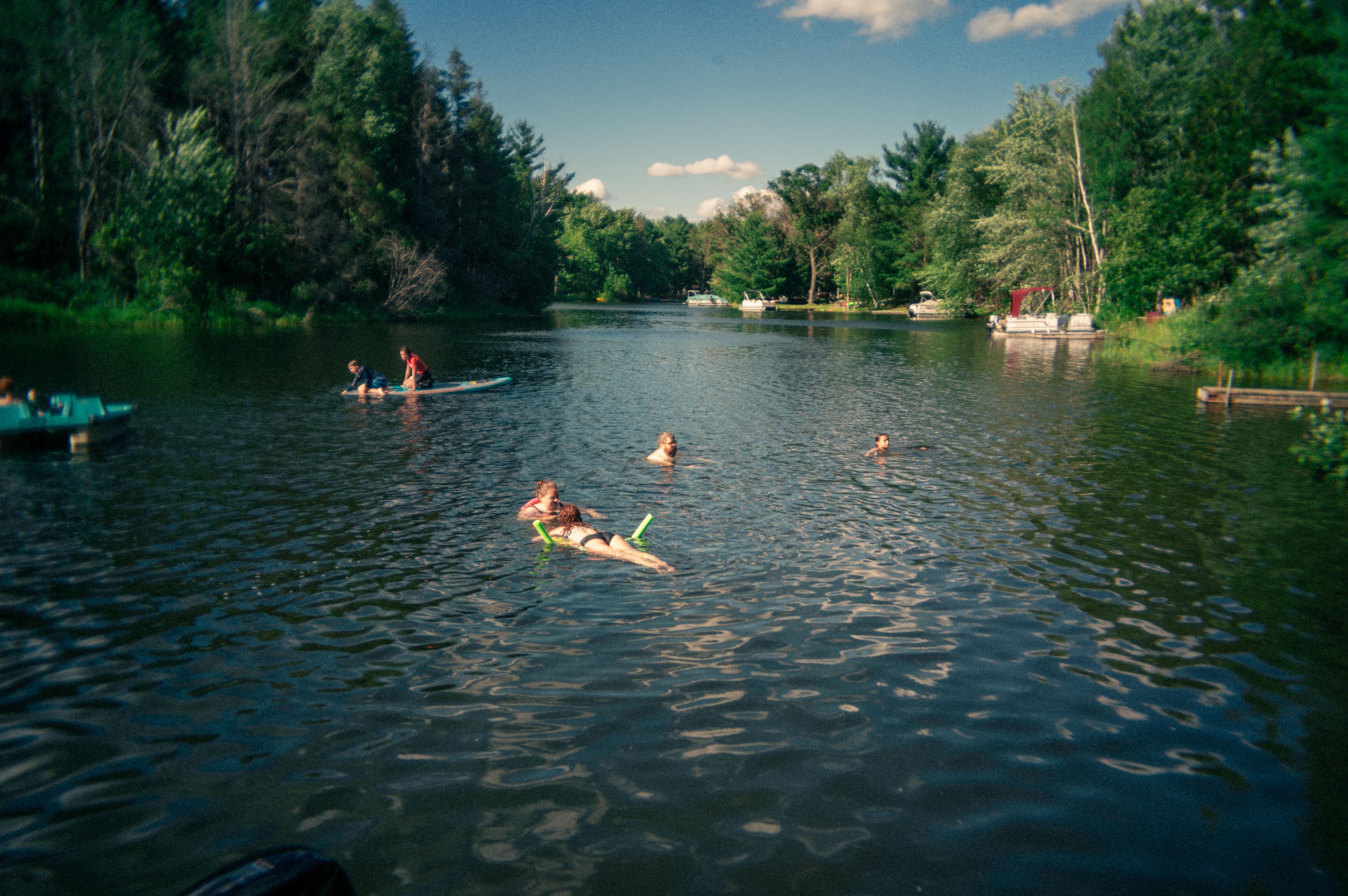 people swimming in a small lake